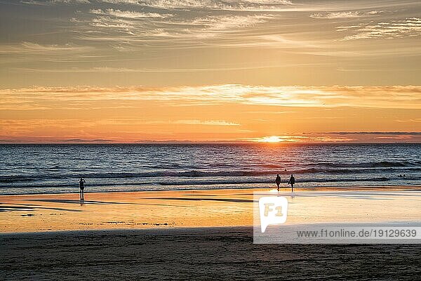 Sonnenuntergang über dem Atlantik mit der Silhouette eines Fotografen  der am Strand von Fonte da Telha  an der Costa da Caparica  Portugal  Bilder von der Brandung macht  Europa