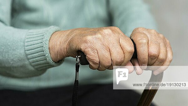 Ältere Frau hält Rohrstock in den Händen