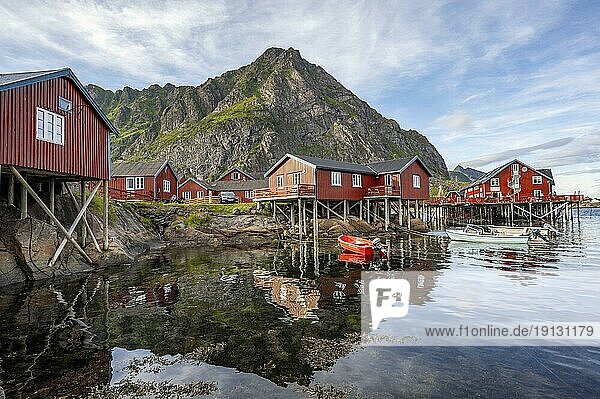 Traditionelle rote Rorbuer Holzhütten,  auf Stelzen am Ufer,  spiegeln sich im Wasser,  Fischerdorf Å i Lofoten,  Lofoten,  Nordland,  Norwegen,  Europa