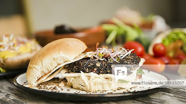 Veggie quinoa burger with sprouts flax seeds white plate
