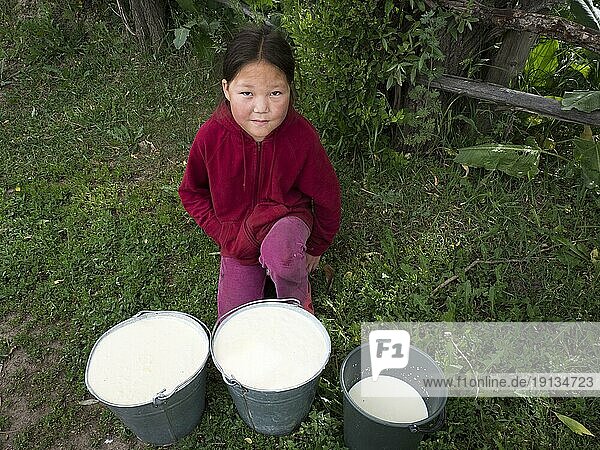 Kleines asiatisches Mädchen mit frisch gemolkener Milch in Eimern  Razdolnoe  Kirgistan  Asien