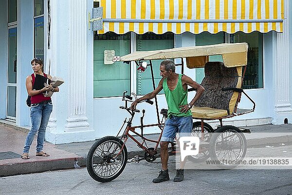 Mann mit dreirädrigem Fahrradtaxi wartet auf Touristen in Cienfuegos  Kuba  Karibik  Mittelamerika