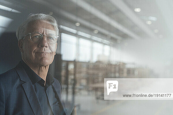 Senior businessman wearing eyeglasses seen through glass