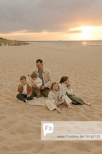 Father with children spending time together at beach