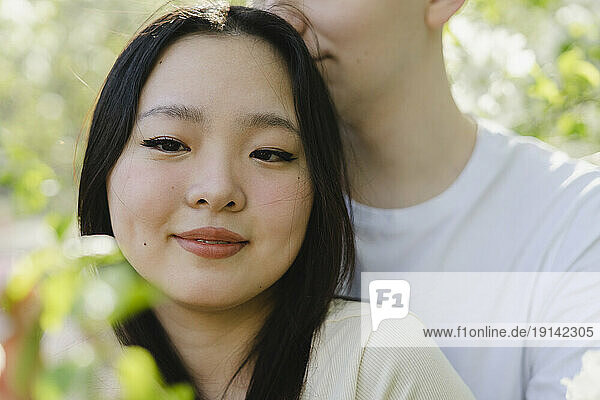 Smiling young woman with boyfriend at park