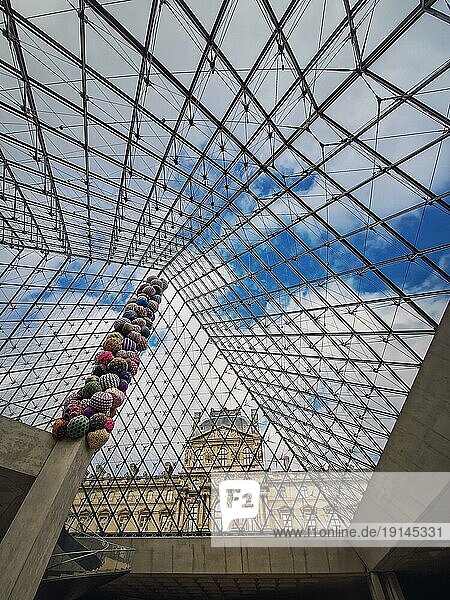 Unterhalb der Glaspyramide des Louvre  vertikaler Hintergrund. Schöne Architekturdetails mit einer abstrakten Mischung aus klassischen und modernen Stilen