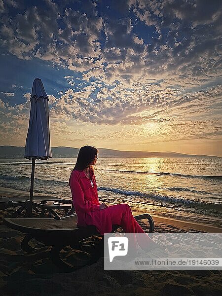 Frau entspannt auf der Sonnenliege als trifft die Morgendämmerung am Strand. Schöne Meer Sonnenaufgang Szene  Sommerurlaub am Meer  Reisen und Urlaub Entspannung Konzept
