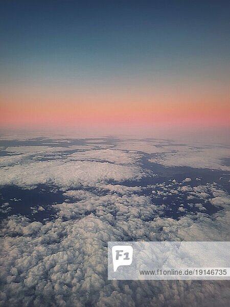 Sonnenuntergang Wolkenlandschaft  Luftaufnahme aus dem Flugzeugfenster über den flauschigen Wolken. Ruhiger Himmel Abendszene  nebliger Nebel. Lufterfrischer  himmlische Schönheit  vertikaler Hintergrund