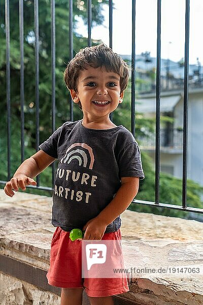 Porträt eines sehr fröhlichen zweijährigen Jungen  der die Sommerferien genießt