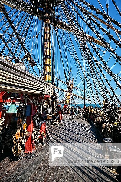 Deck mit Masten und Seilen und Buggeist eines hölzernen Segelschiffs aus der Zeit der Segel