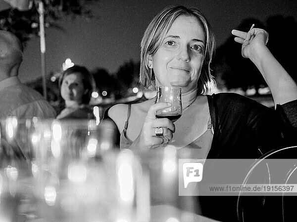 Frau bei Dinnerparty im Freien im Sommer  rauchend und trinkend  schwarzweiß
