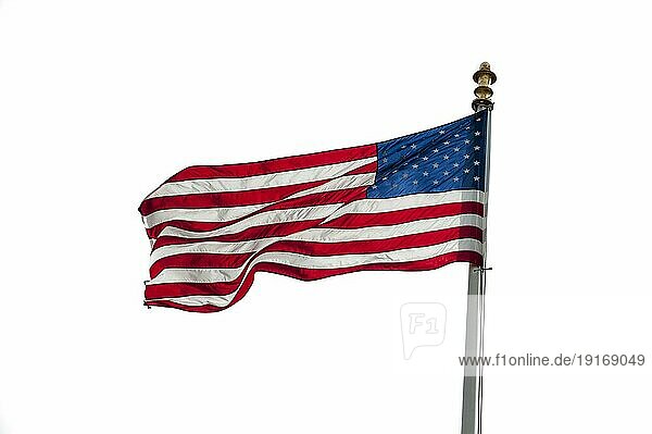Amerikanische Flagge mit US Stars and Stripes weht im Wind auf weißem Hintergrund