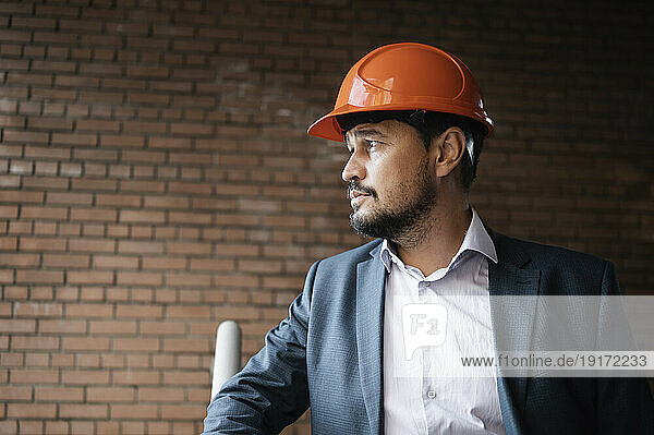 Contemplative engineer standing at construction site