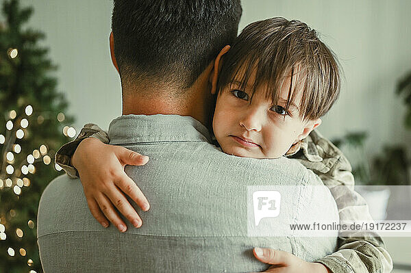 Loving father hugging son at home