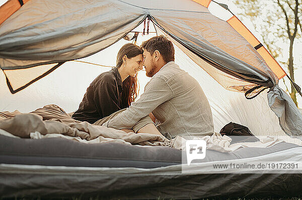 Man embracing happy woman in tent
