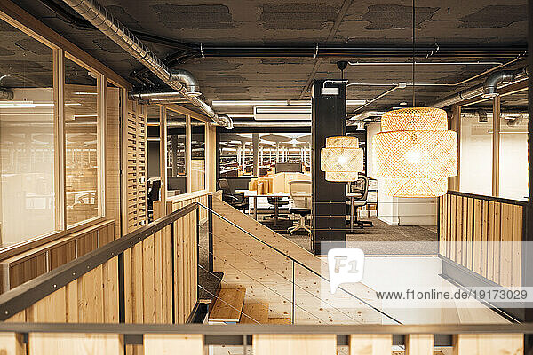 Illuminated office with wooden staircase