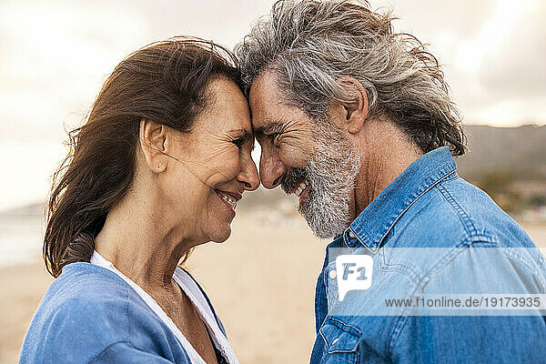 Happy senior couple face to face at beach