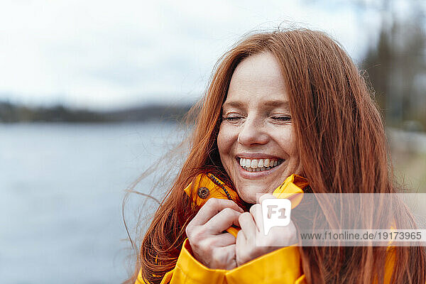 Happy redhead woman with eyes closed