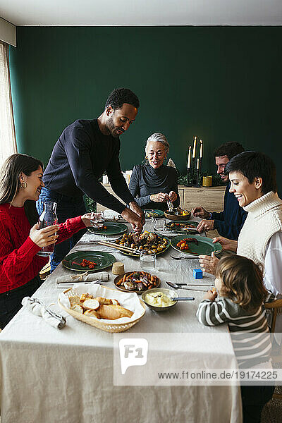 Multiracial family having dinner together at dinning table
