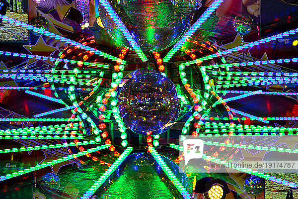 Germany  Bavaria  Wurzburg  Multiple exposure of disco balls and glowing lights in amusement park