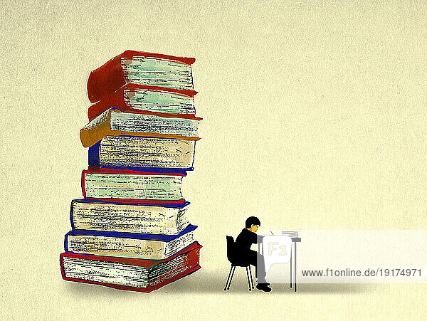 Stack of oversized books behind boy studying at desk
