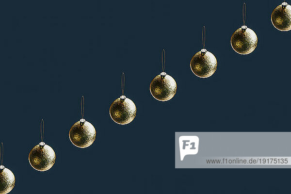 3D render of row of gold-colored Christmas ornaments