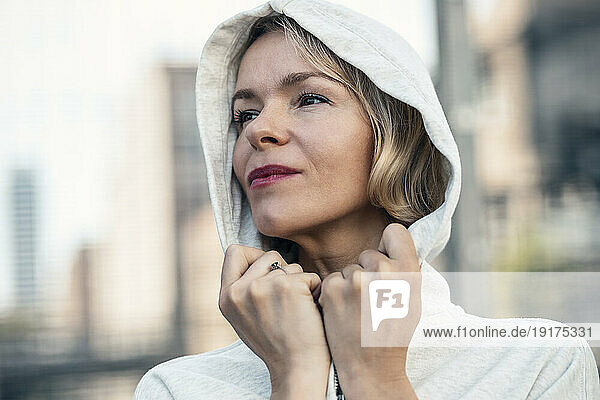 Contemplative woman wearing hooded shirt