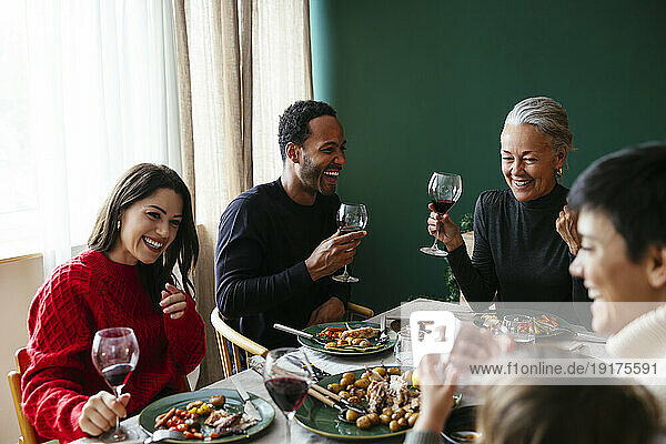 Happy family having red wine and enjoying dinner party on Christmas