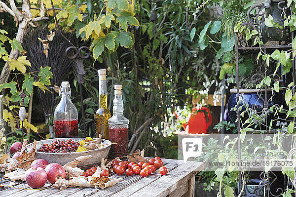 Fruits and various bottled oils on garden table