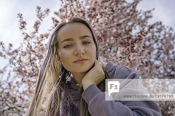 Woman with hand in hair at cherry blossom park