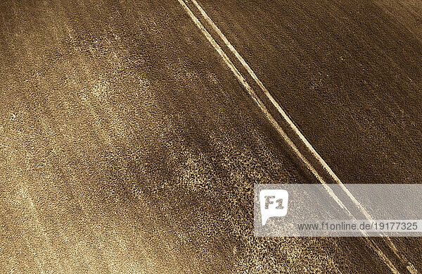 Austria  Upper Austria  Hausruckviertel  Drone view of tire tracks stretching across plowed field