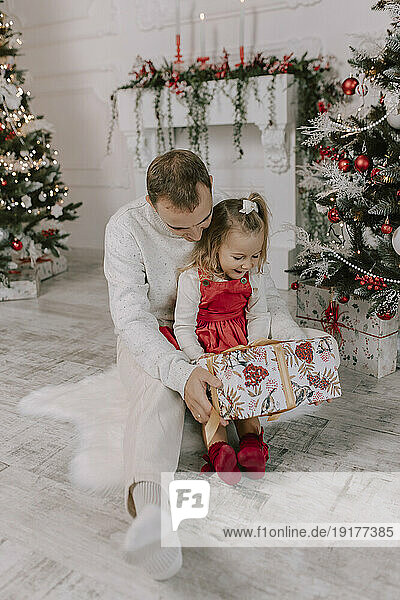 Father and daughter holding christmas present