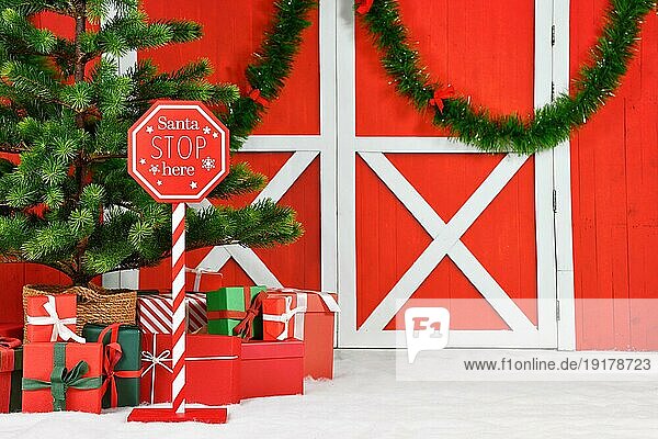 Weihnachten Hintergrund mit Santa Stopschild Geschenkboxen Weihnachtsbaum vor der hölzernen roten Tür mit Girlanden