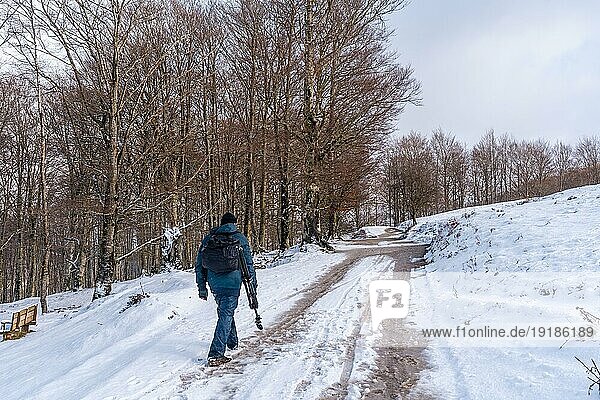 Ein junger Mann spaziert durch die schöne Schneelandschaft des Berges Aizkorri in Gipuzkoa. Verschneite Landschaft bei Winterschnee. Baskenland  Spanien  Europa