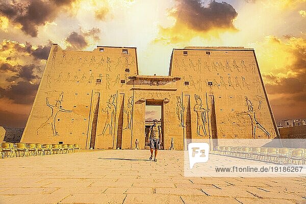 Ein junger Tourist beim Betreten des Tempels von Edfu in der Stadt Edfu  Ägypten. Am Ufer des Nils  geco römischer Bau  Huros gewidmeter Tempel