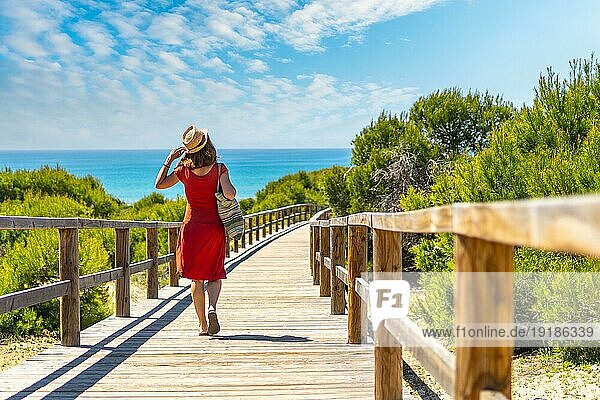 Ein junges Mädchen auf dem Holzweg zum Playa Moncayo in Guardamar del Segura bei Torrevieja  Alicante. Gemeinschaft von Valencia. Spanien  Urlaub am Mittelmeer