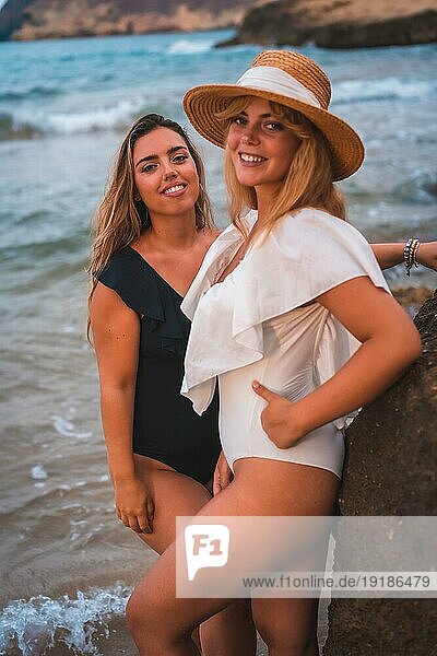 Lebensstil eines lesbischen Paares von kaukasischen Mädchen am Strand im Sommer. Verführerische Blicke der Mädchen schauen in die Kamera
