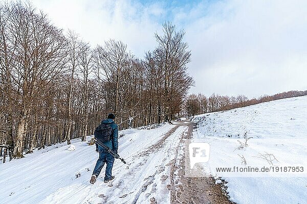 Ein junger Mann spaziert durch die schöne Schneelandschaft des Berges Aizkorri in Gipuzkoa. Verschneite Landschaft bei Winterschnee. Baskenland  Spanien  Europa