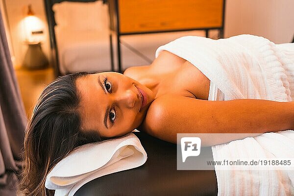 Massage zu Hause  Durchführung einer Massage zu Hause zufriedener Kunde. Mit einer Gesichtsmaske bei der Coronaviruspandemie