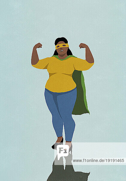 Portrait happy  confident woman flexing biceps in superhero cape and mask