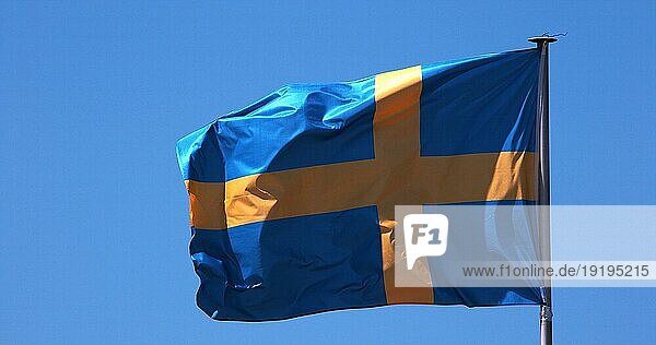 Schwedische Flagge weht im Wind gegen blaün Himmel