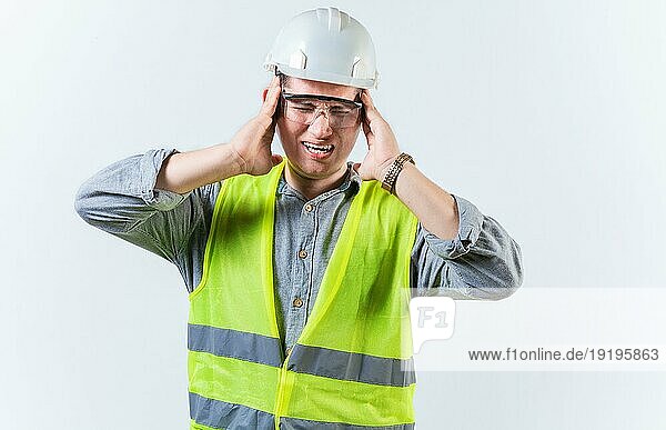 Männlicher Ingenieur mit Kopfschmerzen auf isoliertem Hintergrund. Junger Ingenieur mit Migräne hält seinen Kopf isoliert