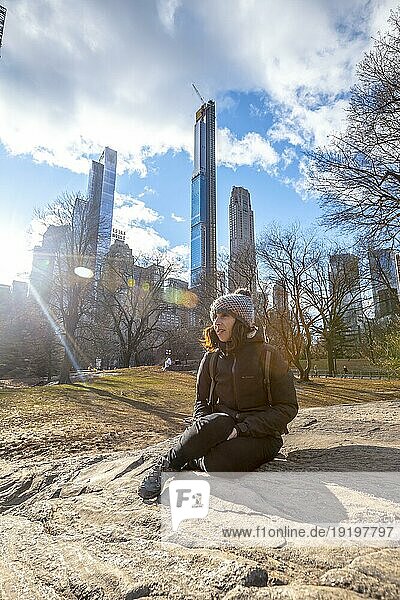New York  Vereinigte Staaten  5. Januar 2020: Ein junger lächelnder Tourist sitzt im Central Park im Winter