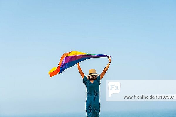 Lgbt Symbol  eine unerkennbare lesbische Person mit dem Rücken zugewandt  die Flagge schwenkend und der blaue Himmel im Hintergrund  Symbol der Homoxesualität