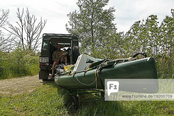Transport eines Bootes mit einem Auto  Auto nimmt einen Trailer ins Schlepp  Naturpark Flusslandschaft Peenetal  Mecklenburg-Vorpommern  Deutschland  Europa