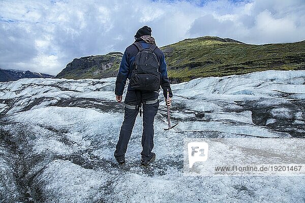 Ein junger Tourist auf dem Eis des Svinafellsjokull Gletschers. Island