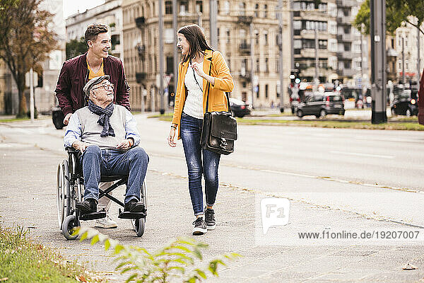 Senior man in wheelchair spending time with his grandchildren