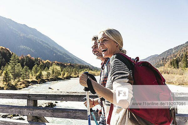 Austria  Alps  happy couple on a hiking trip crossing a bridge