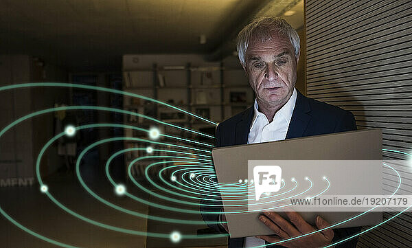 Digital composite image of senior businessman using laptop with swirl lights