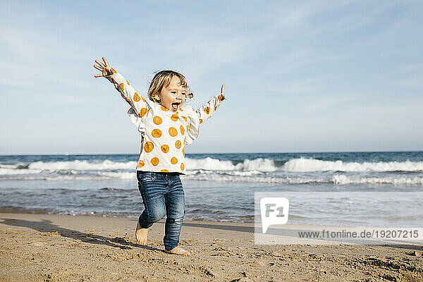 Happy little girl running barefoot on the beach